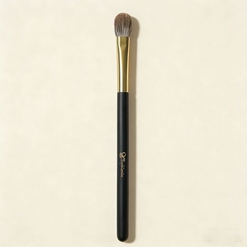 Sophienia eyeshadow blending brush with soft gray bristles, gold ferrule, and black handle on cream background